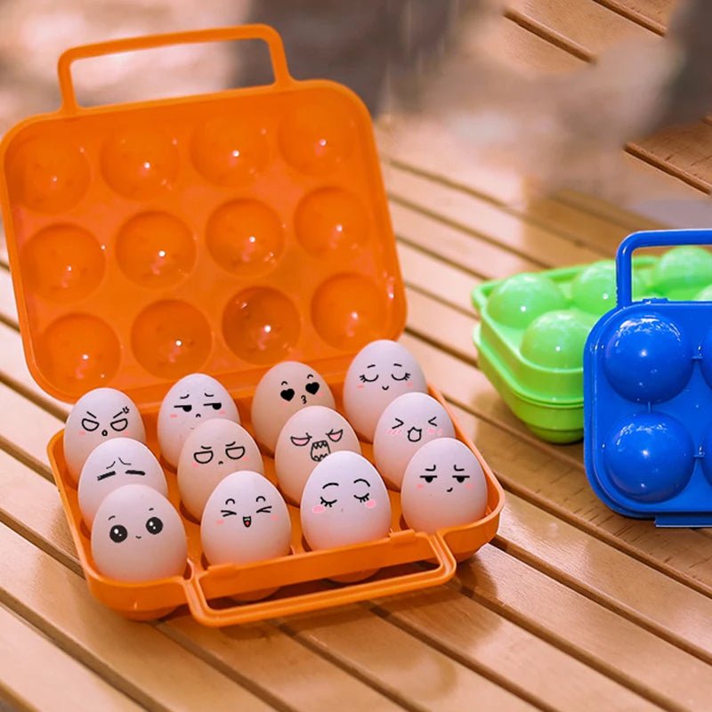 {{Camping Gear {{ Hiking Gear }} }} - {{Tac Treasure Shop }} {{ 12 pack case full with eggs on a wooden camp table. Each egg has an expression drawn on it.  Blue and green 6 pack case closed next to orange case}}