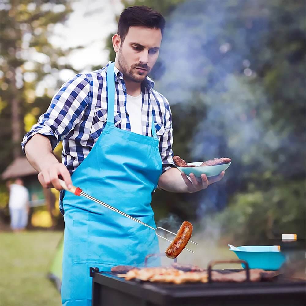 {{Camping Gear {{ Hiking Gear }} }} - {{Tac Treasure Shop }} {{ Man staning over a full grill using Roasting stick to pull cooked food off of the grill. }}